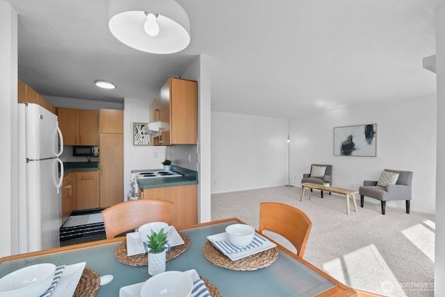 dining space with baseboards and light colored carpet