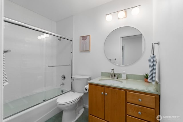 full bathroom with vanity, bath / shower combo with glass door, and toilet