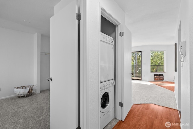 clothes washing area with laundry area, carpet flooring, and stacked washer / dryer