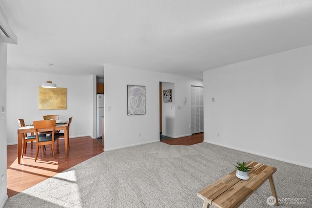 carpeted living room featuring baseboards