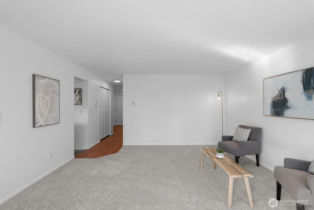 sitting room with baseboards and carpet flooring