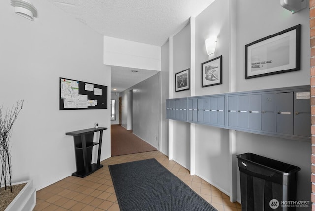 hall with tile patterned flooring and a textured ceiling