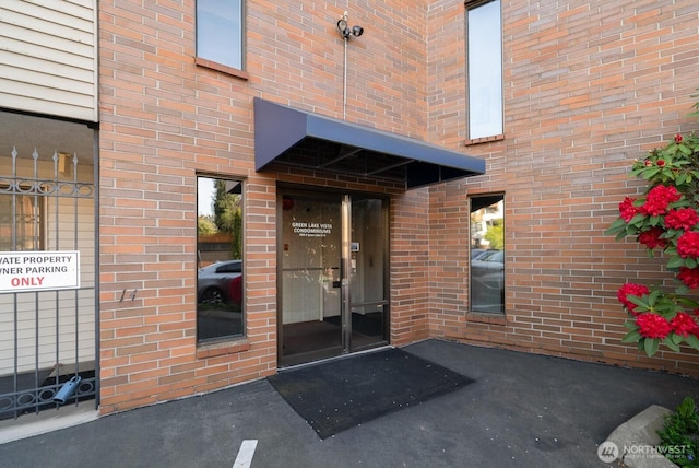 property entrance featuring brick siding