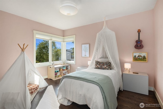 bedroom featuring baseboards and dark wood-type flooring