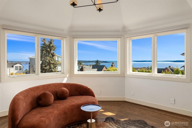 sitting room featuring a water view, baseboards, and wood finished floors