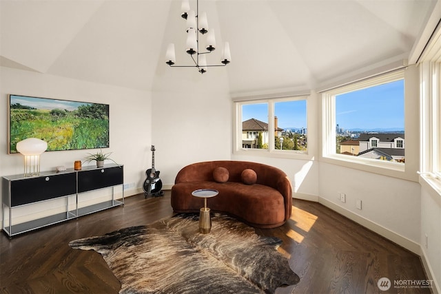 living area featuring high vaulted ceiling, an inviting chandelier, and baseboards