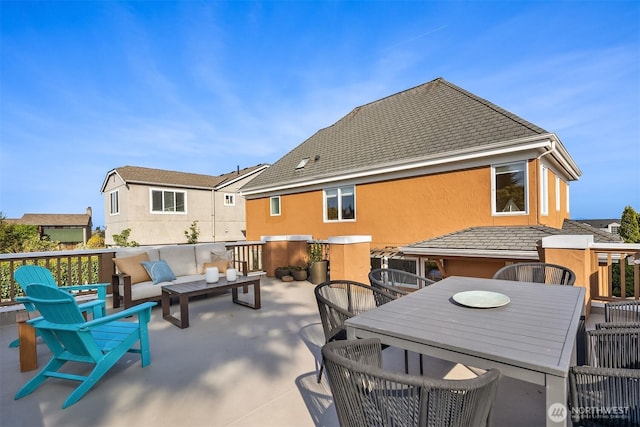 rear view of house with outdoor dining area, stucco siding, and outdoor lounge area