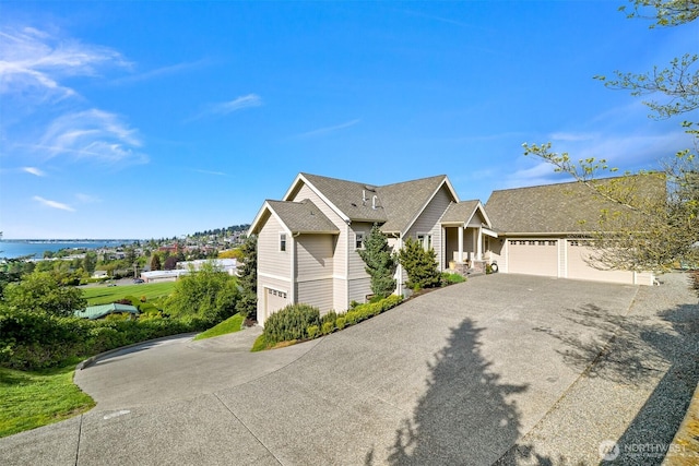 ranch-style house featuring a garage, aphalt driveway, and roof with shingles