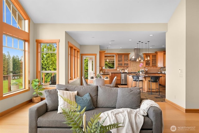 living area featuring baseboards, recessed lighting, and light wood finished floors