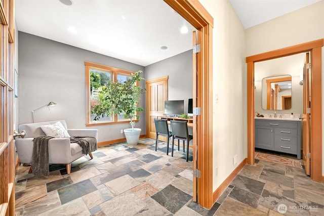 living area with stone tile floors and baseboards
