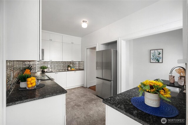 437 NW Pennsylvania Ave, Chehalis, WA 98532 - kitchen featuring freestanding refrigerator, white cabinets, decorative backsplash, and dark stone countertops