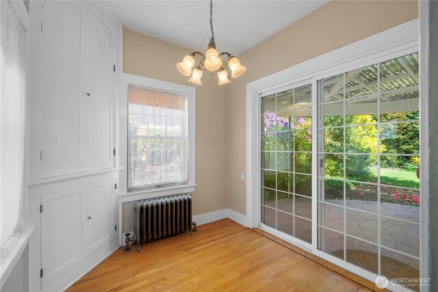 437 NW Pennsylvania Ave, Chehalis, WA 98532 - unfurnished dining area featuring radiator heating unit, baseboards, light wood finished floors, and a chandelier
