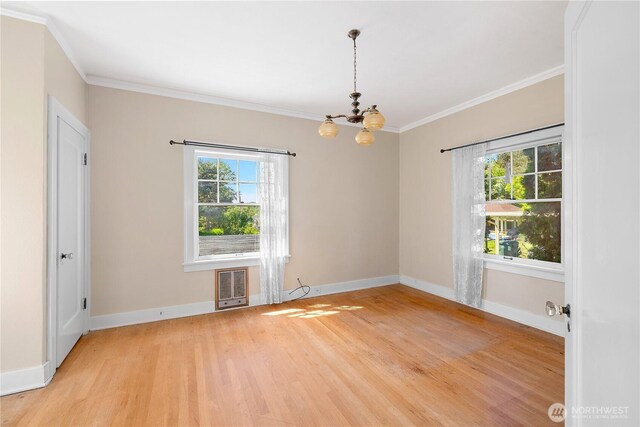 437 NW Pennsylvania Ave, Chehalis, WA 98532 - unfurnished room with ornamental molding, heating unit, baseboards, a chandelier, and light wood finished floors