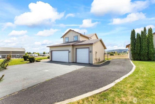 300 Range View Rd, Ellensburg, WA 98926 - view of side of home featuring a garage, a lawn, asphalt driveway, and board and batten siding