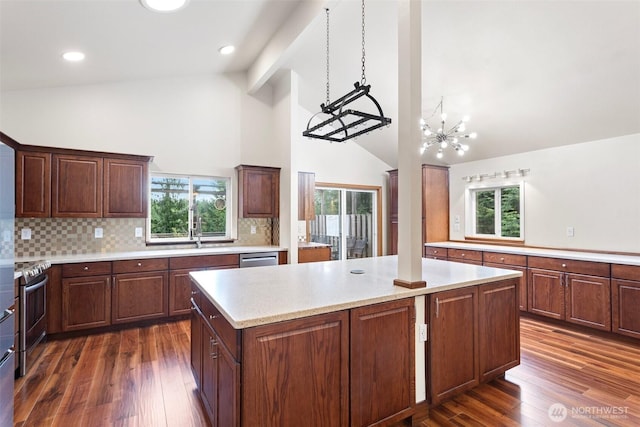kitchen featuring decorative backsplash, dark wood-style floors, a center island, a chandelier, and stainless steel appliances