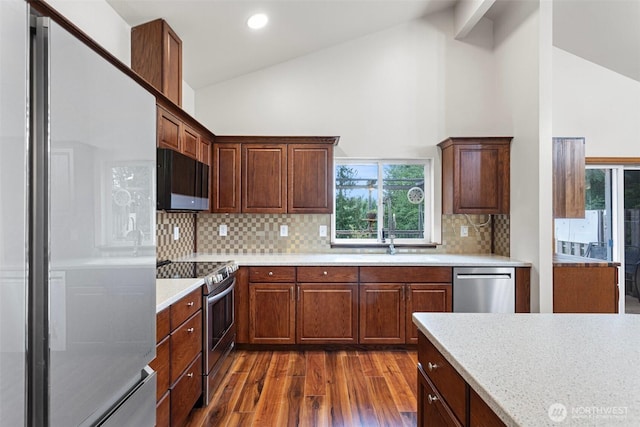kitchen featuring stainless steel appliances, high vaulted ceiling, tasteful backsplash, and dark wood-type flooring