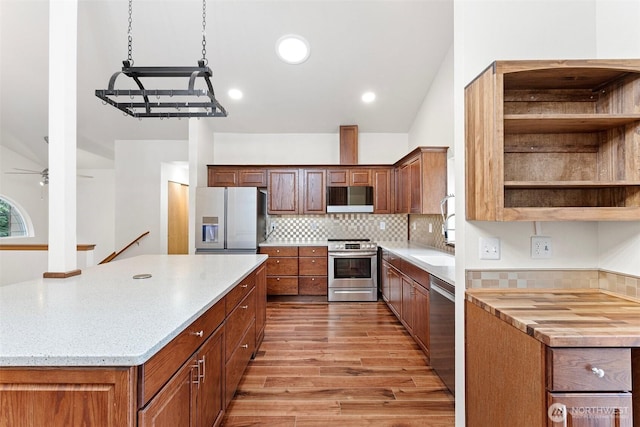 kitchen featuring open shelves, a large island, light wood-type flooring, backsplash, and stainless steel appliances