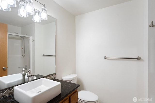 bathroom featuring vanity, a shower with door, and toilet