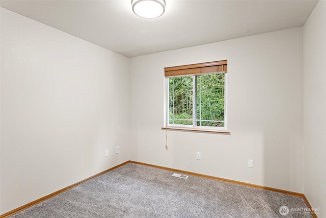 carpeted spare room featuring baseboards and visible vents
