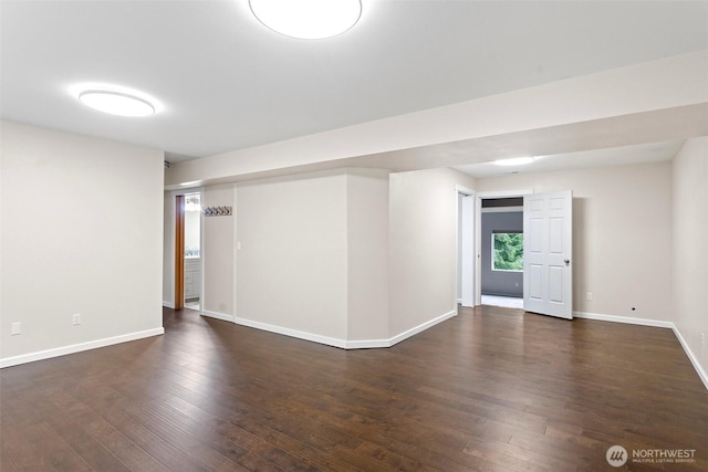 spare room with baseboards and hardwood / wood-style flooring