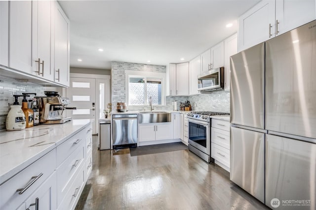 3012 N 30th St, Tacoma, WA 98407 - kitchen featuring decorative backsplash, dark wood-style flooring, a sink, white cabinets, and stainless steel appliances