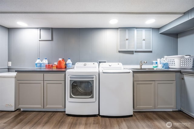 3012 N 30th St, Tacoma, WA 98407 - laundry area with cabinet space, a sink, a decorative wall, wood finished floors, and washer and clothes dryer