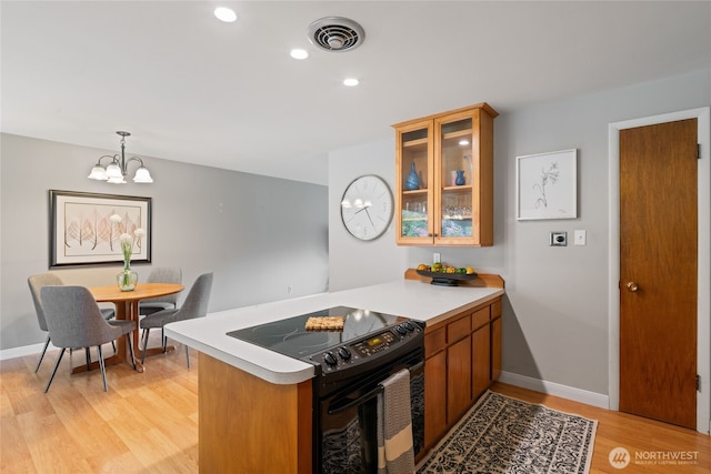 13203 436th Ave SE, North Bend, WA 98045 - kitchen with light countertops, a peninsula, a notable chandelier, and black electric range oven
