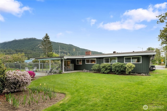 13203 436th Ave SE, North Bend, WA 98045 - back of property with a lawn, fence, a mountain view, and a patio area