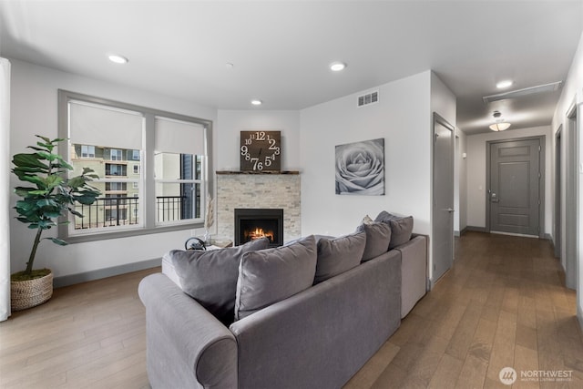 4961 Main St Unit 612, Tacoma, WA 98407 - living room featuring hardwood / wood-style flooring, a warm lit fireplace, baseboards, attic access, and recessed lighting