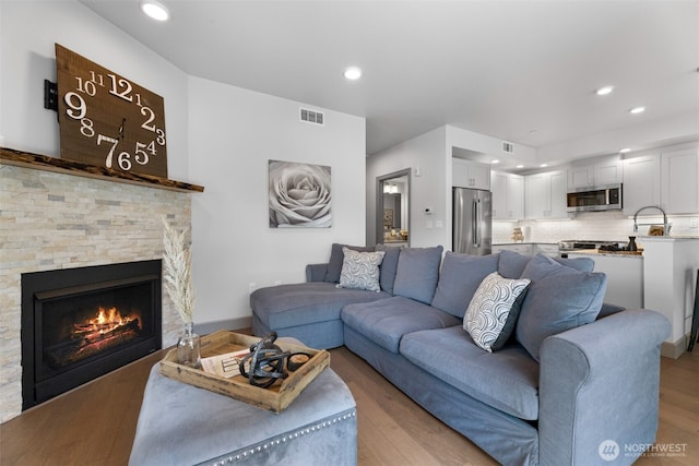 4961 Main St Unit 612, Tacoma, WA 98407 - living room with light wood-style flooring, recessed lighting, and a stone fireplace