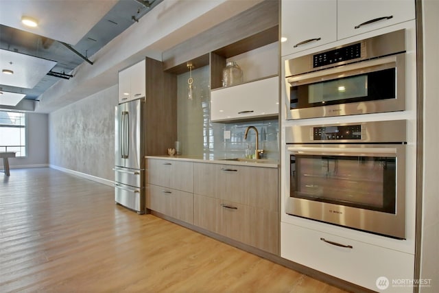 4961 Main St Unit 612, Tacoma, WA 98407 - kitchen with a sink, stainless steel refrigerator, light countertops, light wood-style flooring, and modern cabinets