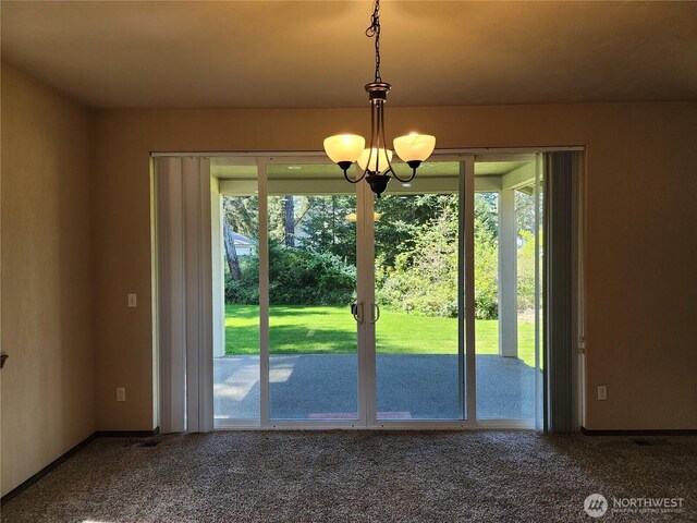 doorway to outside featuring carpet floors, a chandelier, and a wealth of natural light