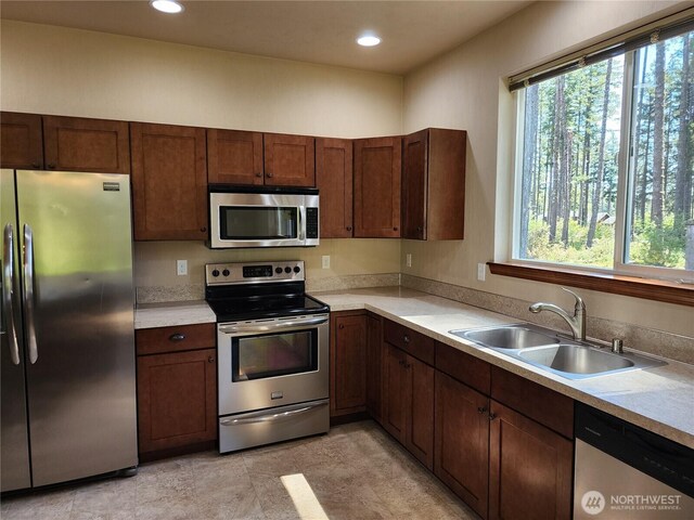 kitchen featuring a sink, light countertops, stainless steel appliances, and recessed lighting