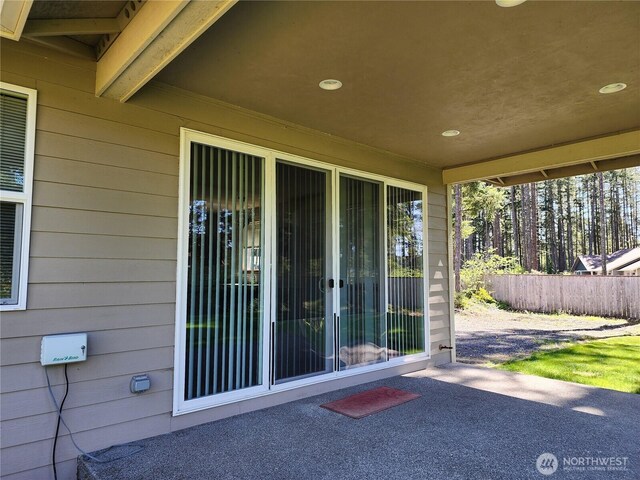 doorway to property featuring fence