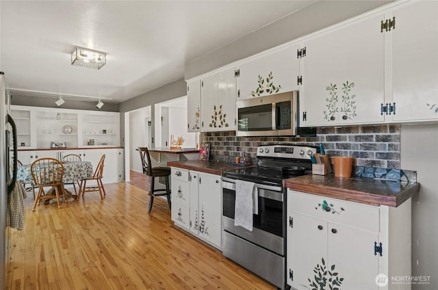 177 Salmon Creek Rd, Okanogan, WA 98840 - kitchen featuring light wood-style flooring, backsplash, white cabinets, and stainless steel appliances