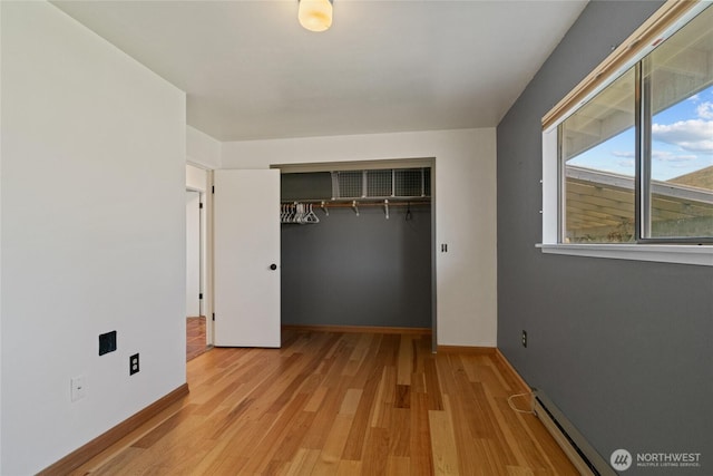 177 Salmon Creek Rd, Okanogan, WA 98840 - unfurnished bedroom with a closet, baseboards, light wood-style flooring, and a baseboard radiator