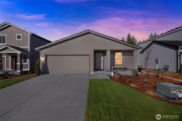 view of front of property featuring an attached garage, driveway, and a front yard
