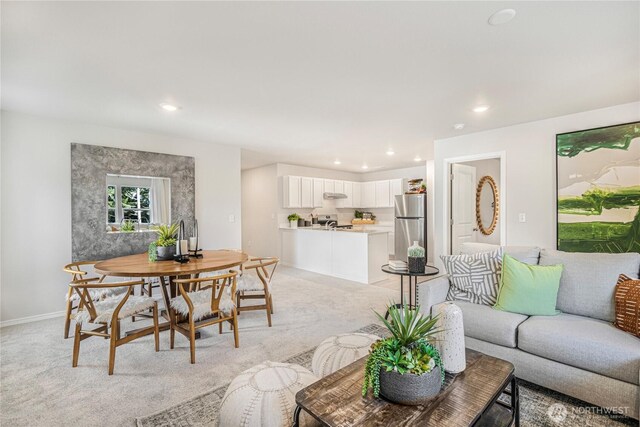 living area featuring baseboards, light carpet, and recessed lighting