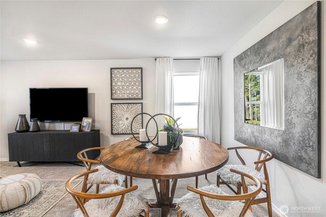 carpeted dining area featuring baseboards