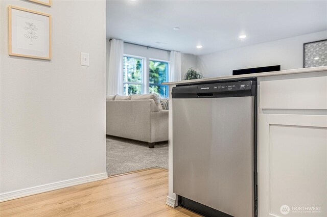 kitchen with baseboards, recessed lighting, white cabinets, light wood finished floors, and dishwasher