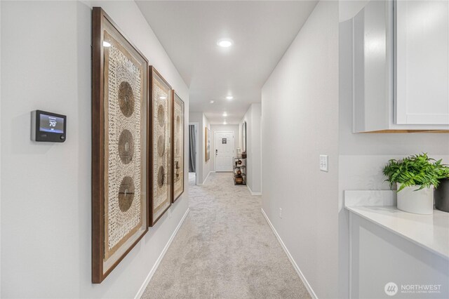 corridor featuring baseboards, light carpet, and recessed lighting