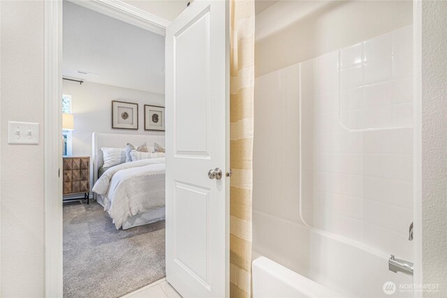 ensuite bathroom featuring shower / tub combo with curtain and connected bathroom