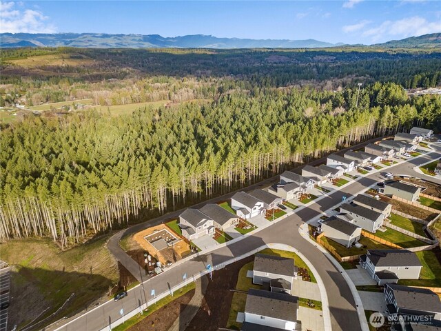 birds eye view of property featuring a residential view, a mountain view, and a wooded view