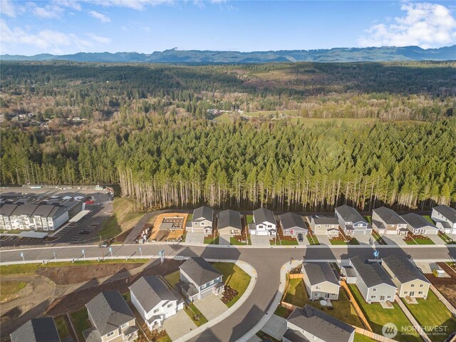 birds eye view of property with a view of trees, a residential view, and a mountain view