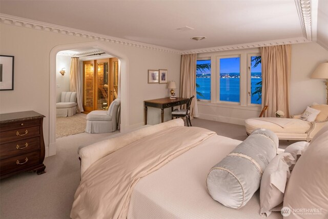 carpeted bedroom featuring arched walkways