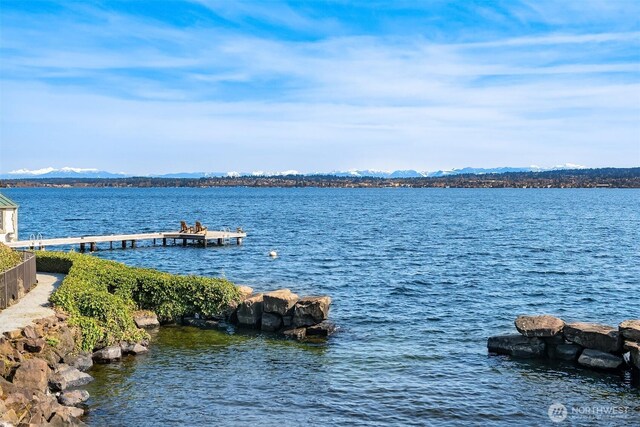 property view of water featuring a mountain view and a dock
