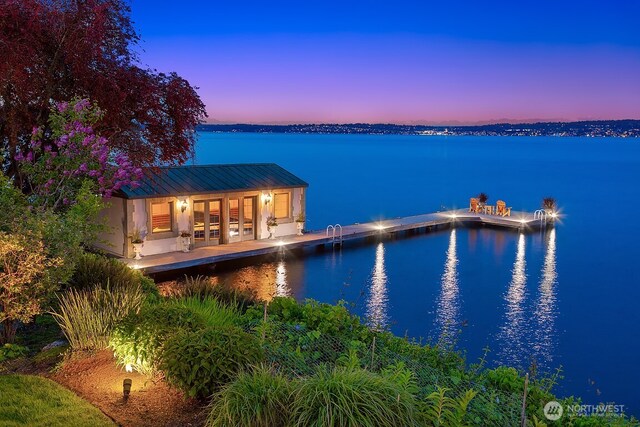 exterior space with a water view, french doors, and metal roof