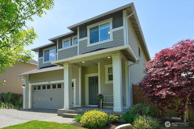 view of front of home featuring covered porch, driveway, and a garage