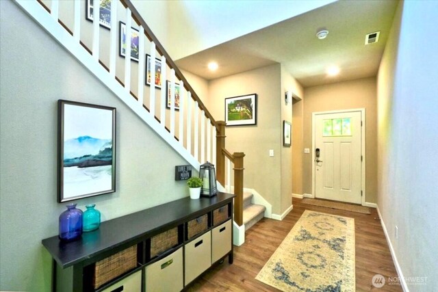 foyer featuring recessed lighting, baseboards, dark wood-type flooring, visible vents, and stairway