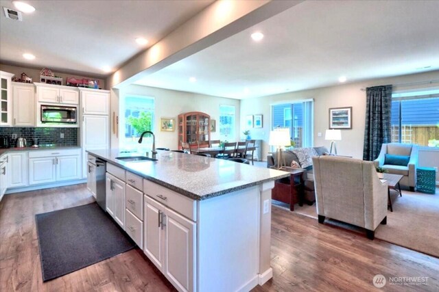 kitchen featuring white cabinets, appliances with stainless steel finishes, a sink, wood finished floors, and visible vents